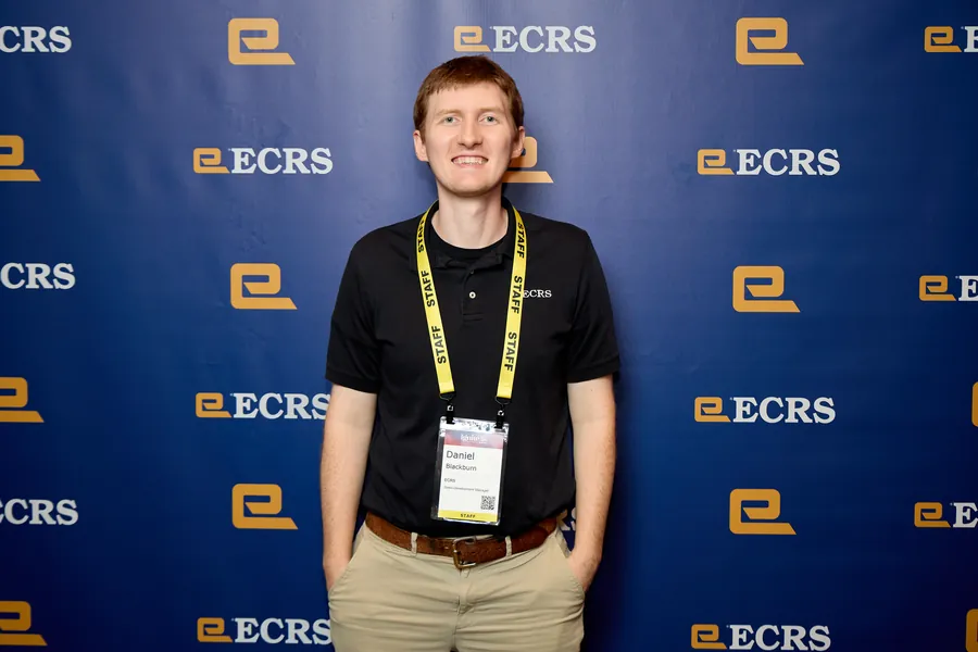 Attendee posing in front of the ECRS backdrop at the ECRS Ignite 2026 conference