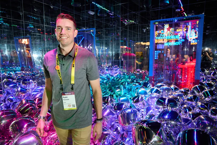 Attendee smiling in a neon mirror-ball room at the ECRS Ignite 2026 closing party