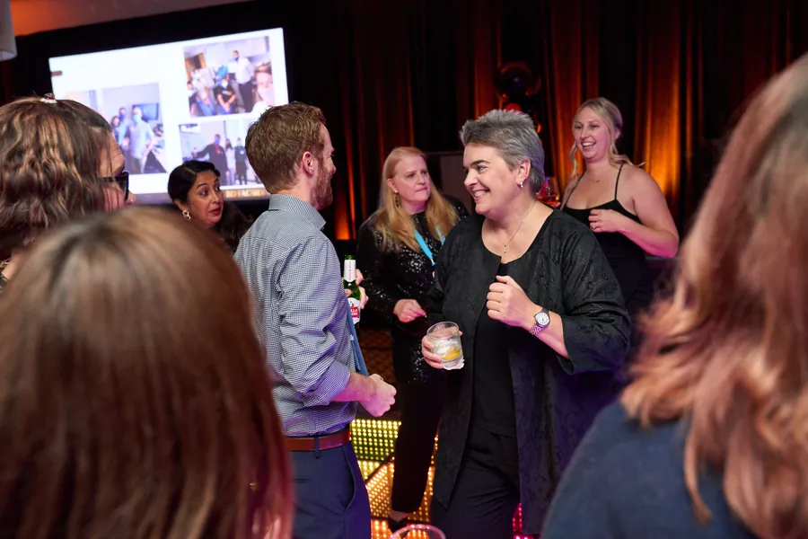 Attendees laughing and talking at a reception, event photography