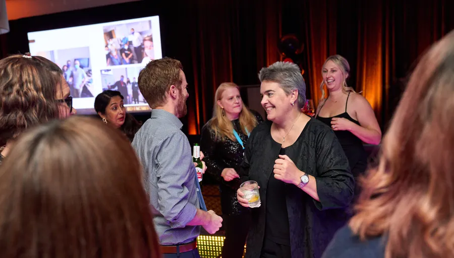 Attendees laughing and talking at a reception, event photography