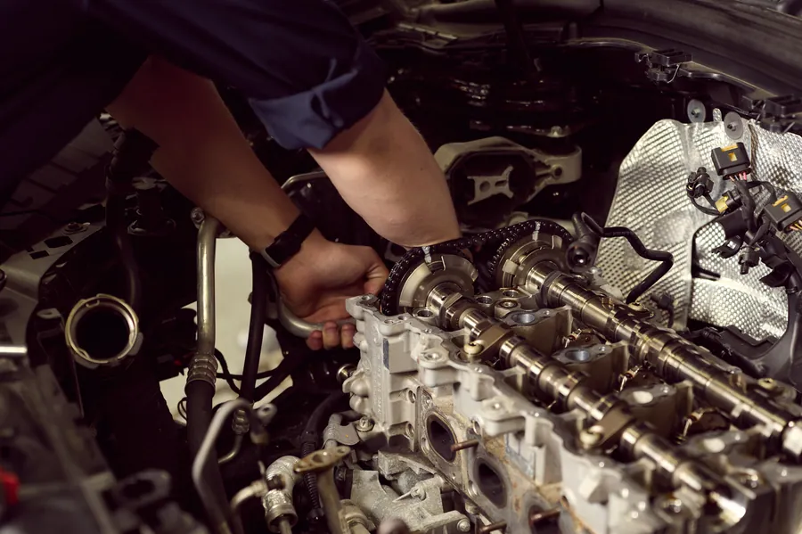 Close-up of a mechanic's hands working on an engine's camshaft