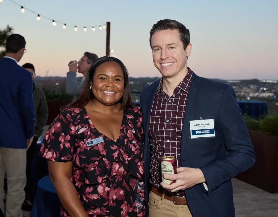 Couple posing under rooftop string lights at dusk, Frazier & Deeter Nashville open house
