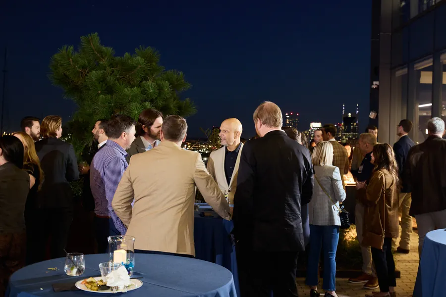 Crowd on the rooftop at night at the Frazier & Deeter Nashville open house