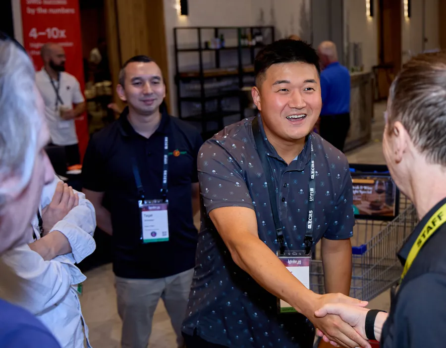 Exhibitor shaking hands with an attendee on the expo floor at ECRS Ignite 2026