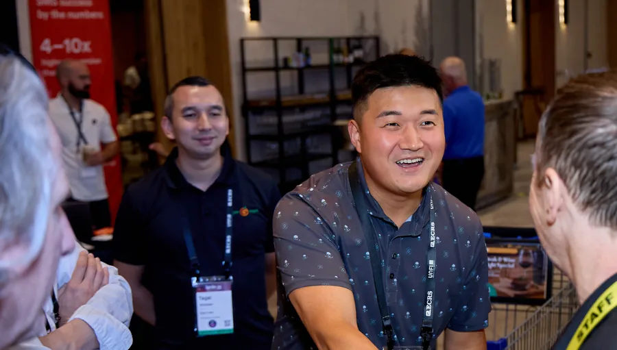 Exhibitor shaking hands with an attendee on the expo floor at ECRS Ignite 2026