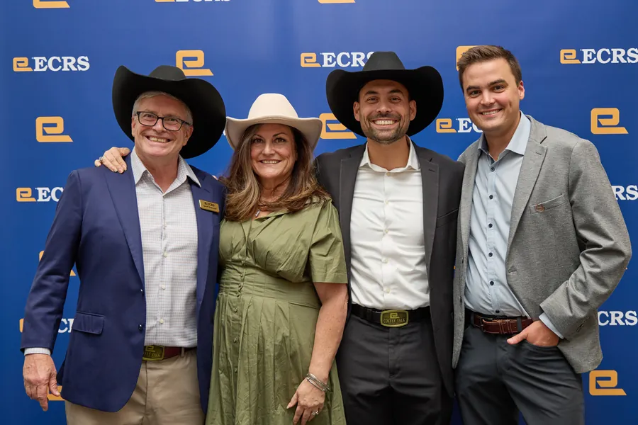 Four attendees in cowboy hats posing on the ECRS backdrop at ECRS Ignite 2026