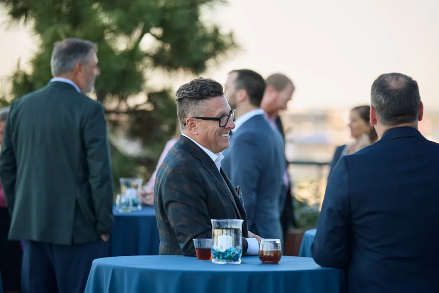 Guest smiling at a rooftop table overlooking the river at the Frazier & Deeter Nashville open house