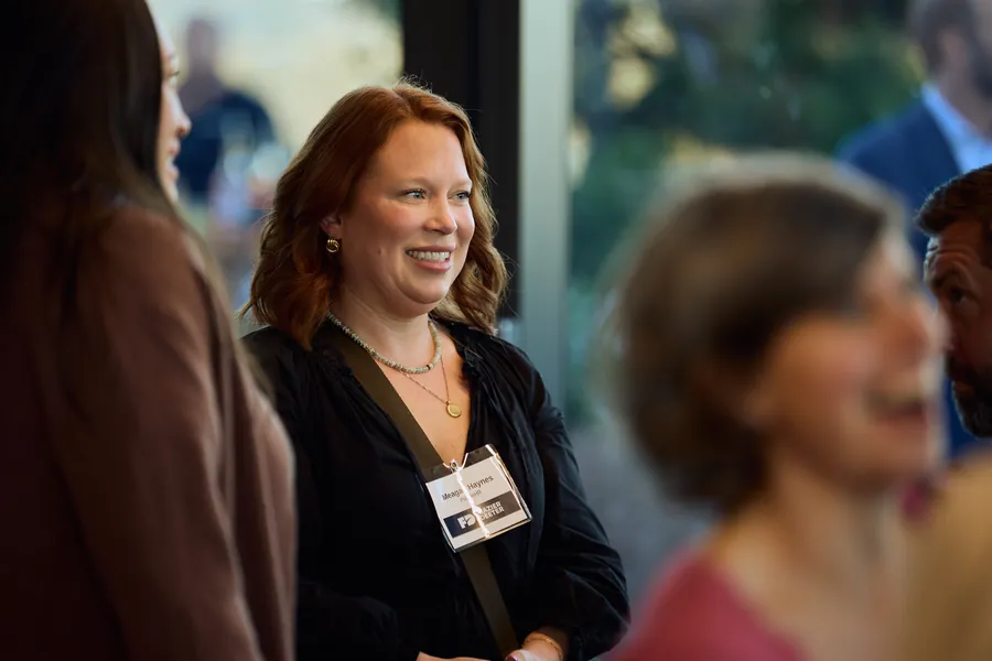 Guest smiling during a conversation at the Frazier & Deeter Nashville open house