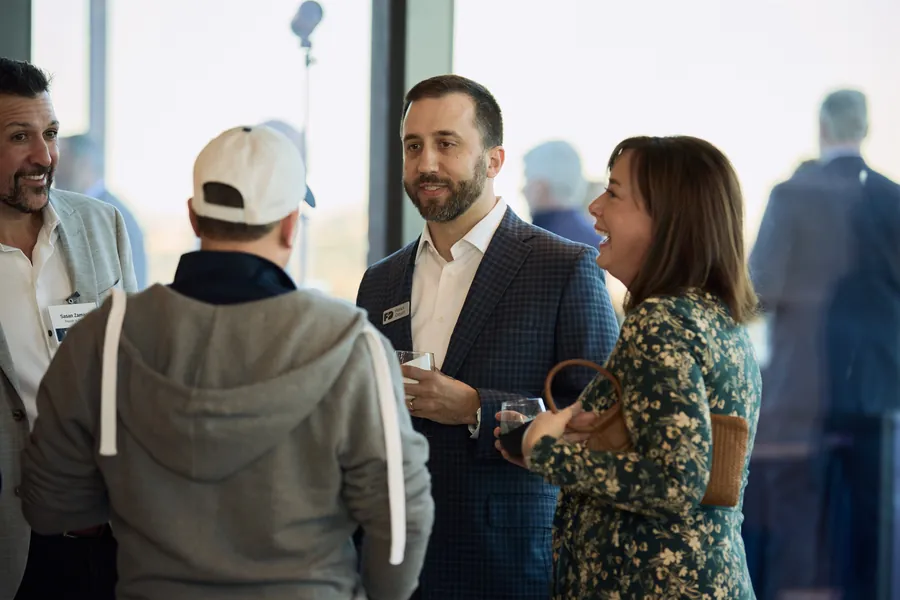 Guests mingling by the windows at the Frazier & Deeter Nashville open house