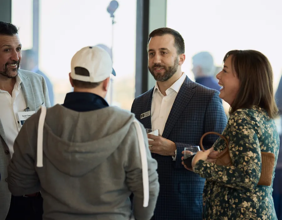 Guests mingling by the windows at the Frazier & Deeter Nashville open house