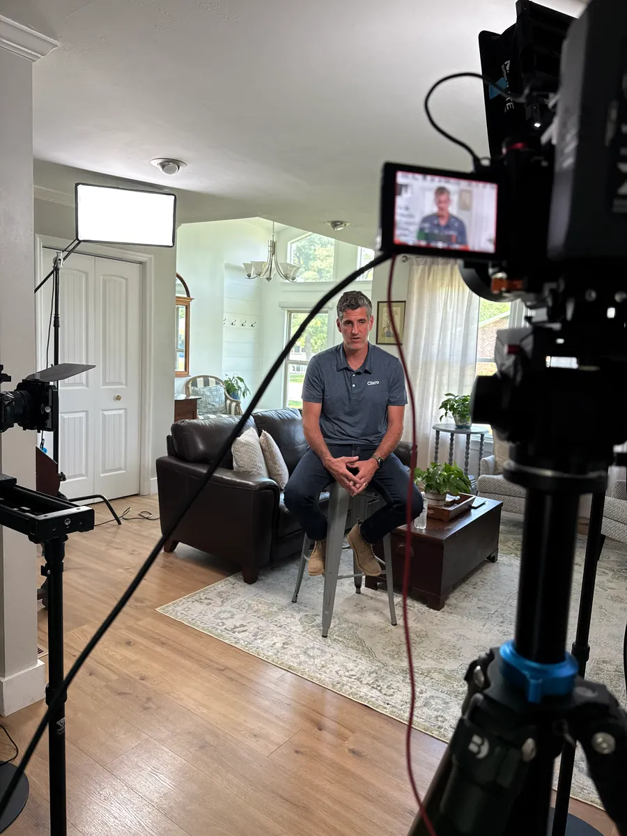 Interview subject seated on a couch in a styled living room video set