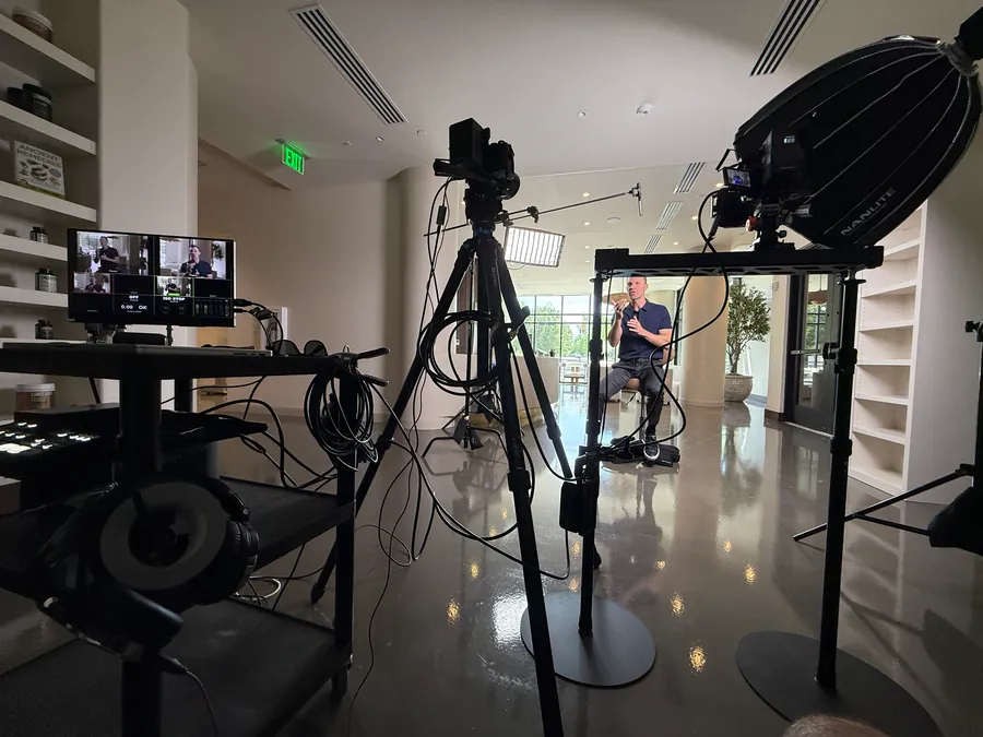 Interview video setup with a camera, softbox, and umbrella lighting in an office lobby