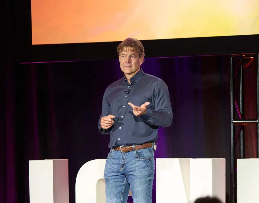 Keynote speaker in front of the giant IGNITE letters at ECRS Ignite 2026