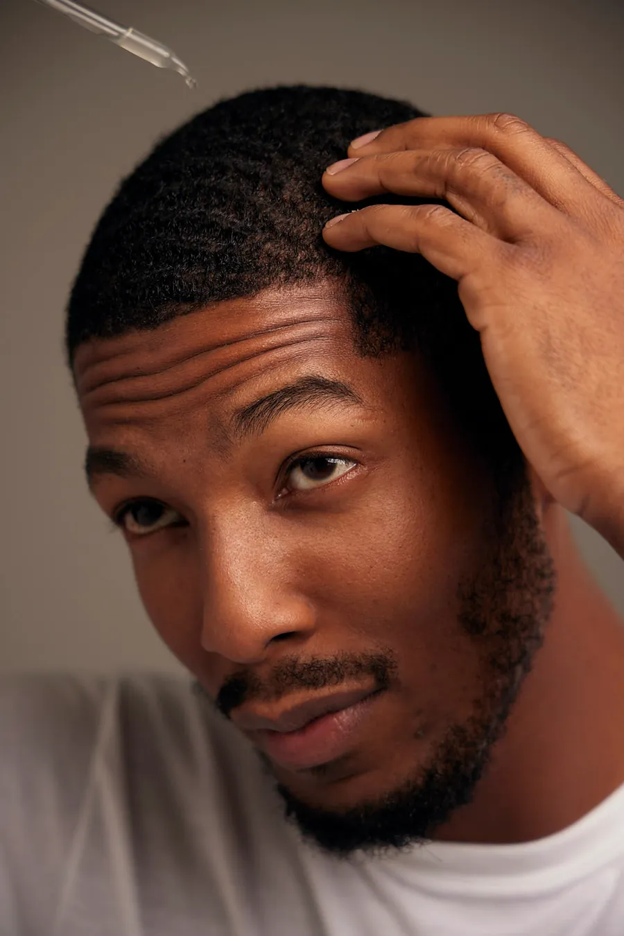 Man running his hand through his hair with a dropper above, Zenagen rebrand campaign