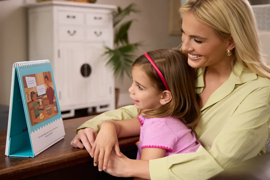 Mother and young daughter reading an activity book together at a counter
