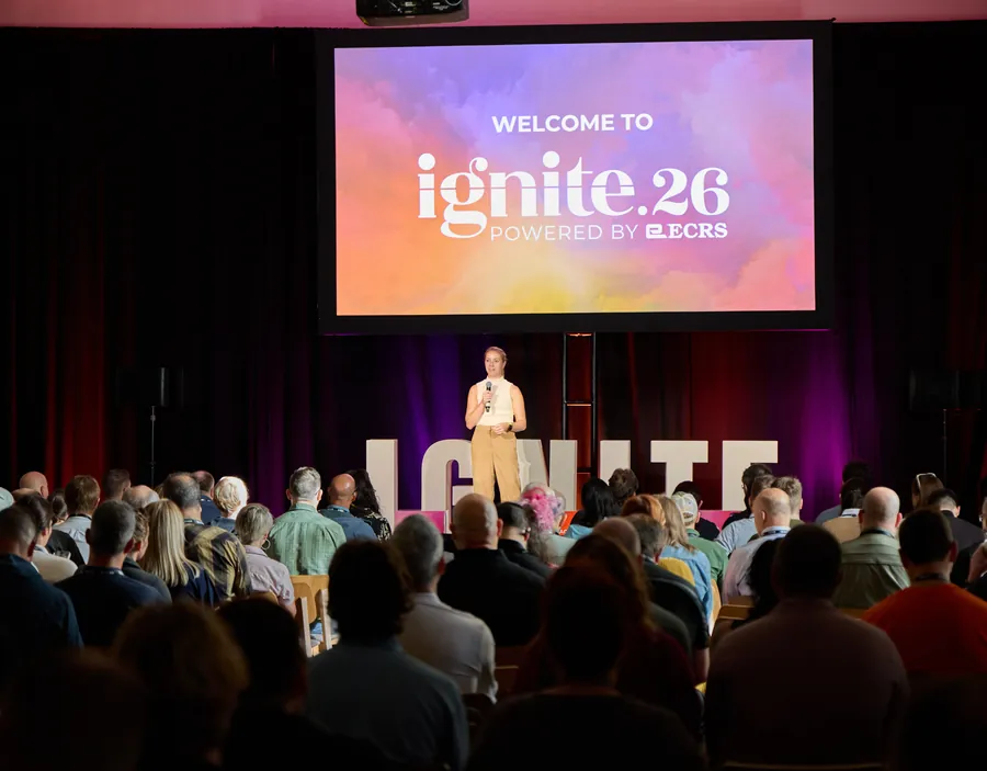 Packed general session under the Welcome to Ignite 26 screen at ECRS Ignite 2026