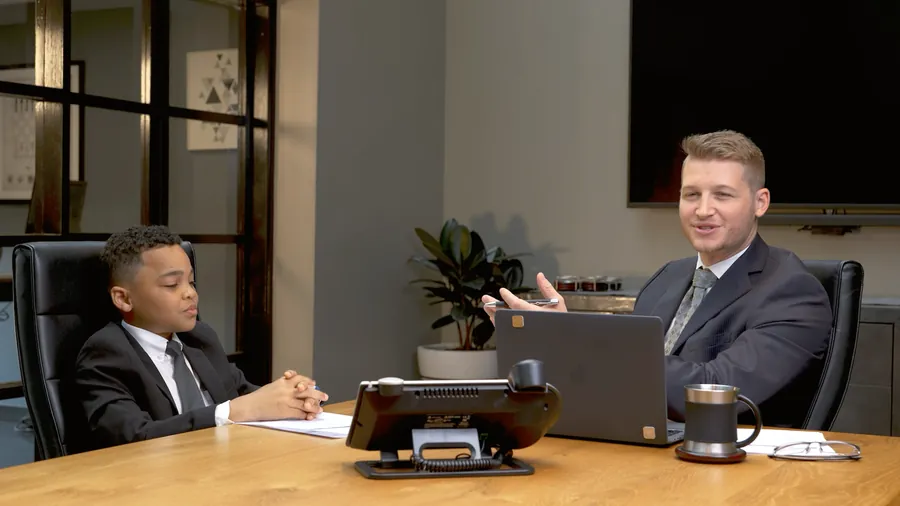 Playful discovery-call video with a young 'executive' leading a business meeting — click to play