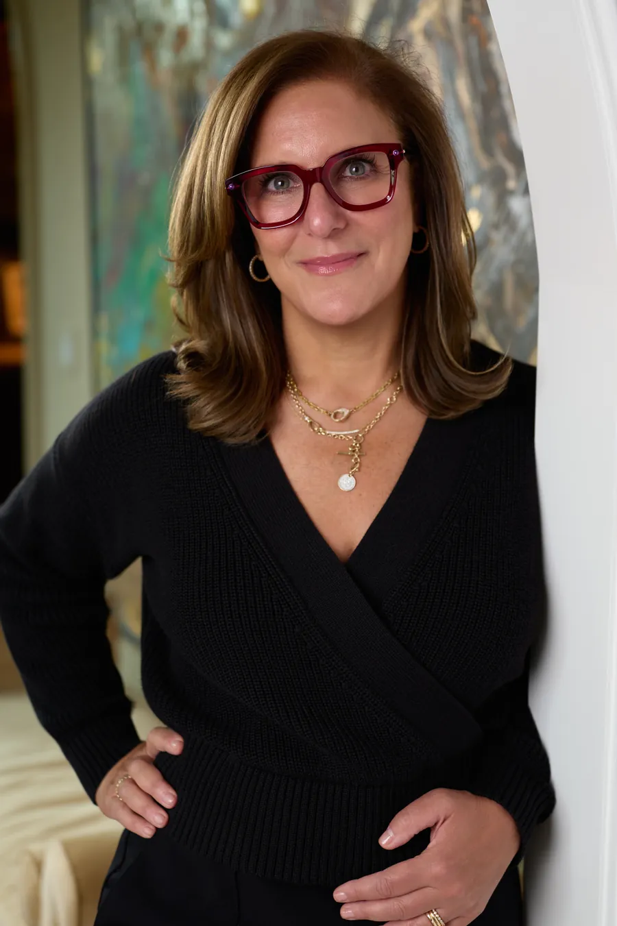 Portrait of a woman in red glasses in front of an abstract painting, art consultant branding photo