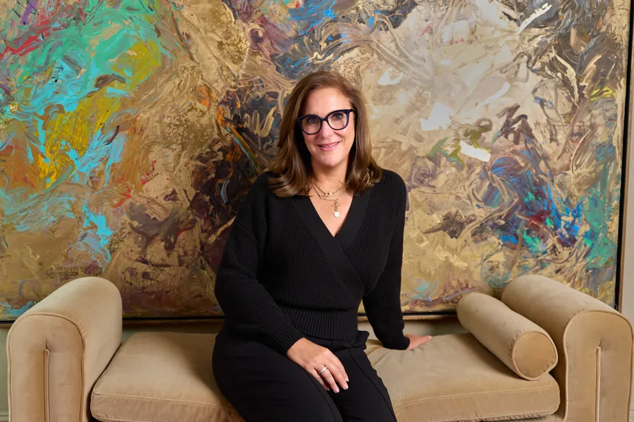 Portrait of the art consultant seated in front of a large abstract painting