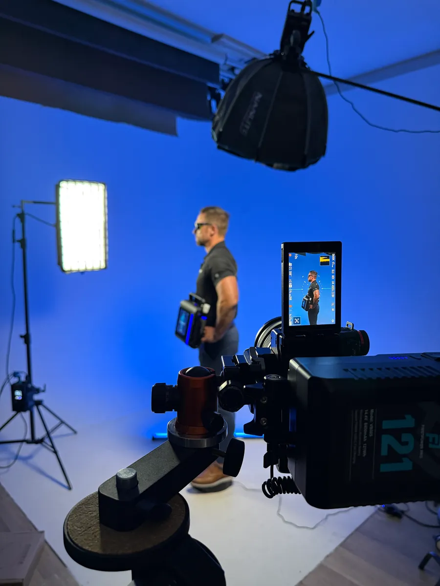 Portrait video shoot with softbox lighting against a blue backdrop