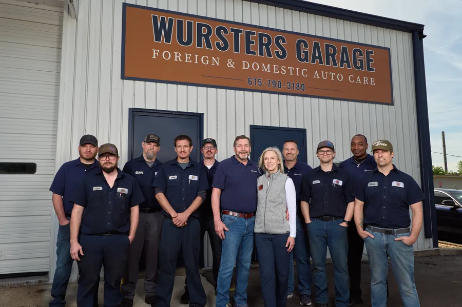 The full Wursters Garage team posing together in front of the shop sign