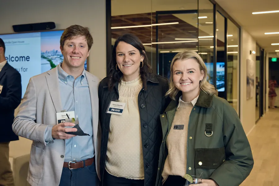 Three guests posing in the office hallway at the Frazier & Deeter Nashville open house