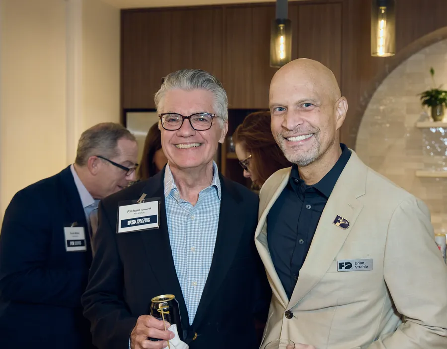 Two men laughing together in the new office at the Frazier & Deeter Nashville open house