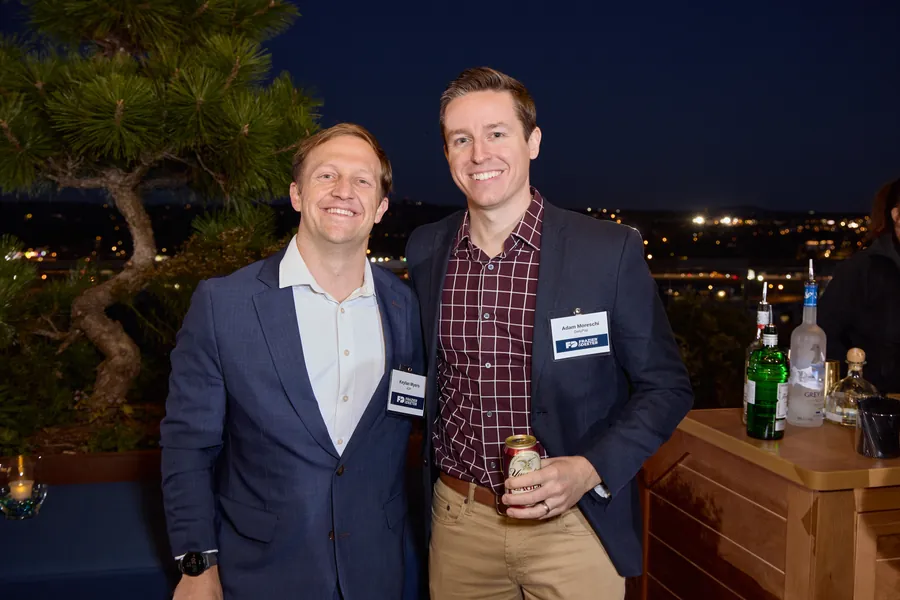 Two men posing by the rooftop bar at night, Frazier & Deeter Nashville open house