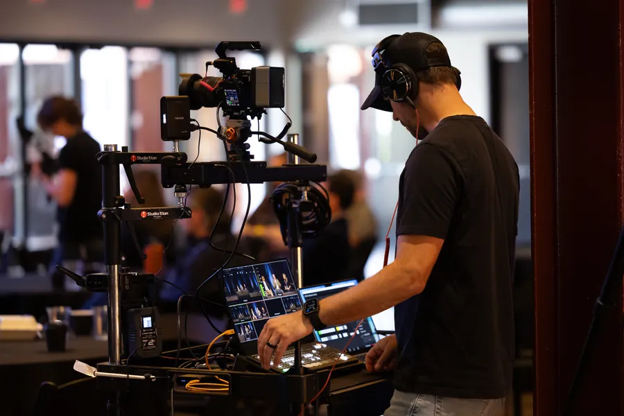 Video crew operating a handheld gimbal camera rig indoors
