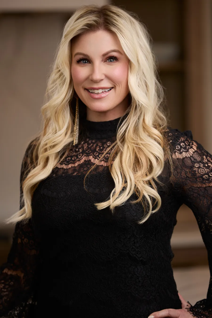 Woman with long dark hair in a black lace top, brand portrait
